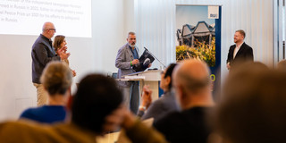 Friedensnobelpreisträger Dmitry Muratov hält eine Rede vor einem Publikum.